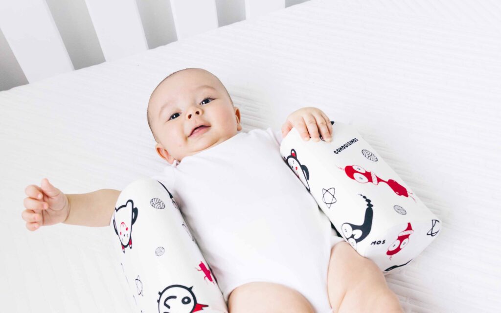 bebé acostado en una almohada cómoda de color blanco con dibujos